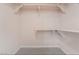 Walk-in closet features carpeted floors and wooden shelves for optimal storage solutions at 6914 Emerald Springs Ln, Las Vegas, NV 89113