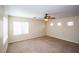 This spacious bedroom has neutral carpet, a ceiling fan and bright natural light at 8063 Sundance Valley Dr, Las Vegas, NV 89178