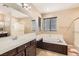 Bathroom featuring a soaking tub, dual vanity sinks, and a glass shower at 8109 Mountain Forest Ct, Las Vegas, NV 89129