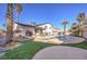 This backyard features a pool with spa, patio, palm trees and artificial grass at 889 Monika Way, Las Vegas, NV 89119