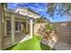 Inviting backyard offers a covered patio with an artificial lawn and lush landscaping for a perfect retreat at 10205 Birch Bluff Ln, Las Vegas, NV 89145