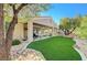 Landscaped backyard with artificial turf and mature trees at 10236 Rio De Thule Ln, Las Vegas, NV 89135