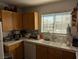 Well-lit kitchen area featuring a window view, tiled countertops, and oak cabinets at 10524 Pine Gardens Ct # 203, Las Vegas, NV 89144