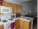 Kitchen includes stove, microwave, and wood cabinets with view into another room at 10524 Pine Gardens Ct # 203, Las Vegas, NV 89144