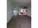 Spacious living room with large windows, carpet, and access to the kitchen area enhancing the open floor plan at 10524 Pine Gardens Ct # 203, Las Vegas, NV 89144