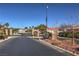 Gated community entrance with stone pillars and sign reading 'Bella Vicenza' surrounded by desert landscaping at 10649 Bella Ordaz Way, Las Vegas, NV 89141