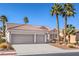 Charming home featuring a three-car garage, desert landscaping and mature palm trees at 10649 Bella Ordaz Way, Las Vegas, NV 89141