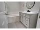 Modern bathroom featuring a tub and a gray vanity with a white countertop and round mirror at 1700 Hills Of Red Dr # 202, Las Vegas, NV 89128