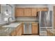 This kitchen is equipped with stainless steel appliances, wood cabinetry, and granite countertops at 1700 Hills Of Red Dr # 202, Las Vegas, NV 89128