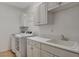 Well-lit laundry room with modern appliances, sink, and ample storage space at 1700 Hills Of Red Dr # 202, Las Vegas, NV 89128