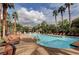 Inviting pool area with numerous lounge chairs and palm trees at 1700 Hills Of Red Dr # 202, Las Vegas, NV 89128