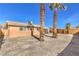 Spacious backyard with gravel, two palm trees, and a covered patio at 4857 E Monroe Ave, Las Vegas, NV 89110