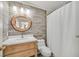 Modern bathroom with a round mirror and wood vanity at 5915 Ablette Ave, Las Vegas, NV 89122