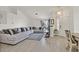 Bright living room featuring a large sectional sofa, wood floors, and view to front door at 5915 Ablette Ave, Las Vegas, NV 89122