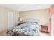 Well-lit bedroom with floral bedding, tiled floor, white headboard, and matching nightstands at 6409 Youngmont Ave, Las Vegas, NV 89103