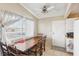 Inviting dining room featuring a long wooden table with chairs, neutral walls, natural light, and a ceiling fan at 6409 Youngmont Ave, Las Vegas, NV 89103