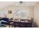 Inviting dining room featuring a long wooden table with chairs, neutral walls, natural light, and a ceiling fan at 6409 Youngmont Ave, Las Vegas, NV 89103