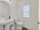 Cozy half bath with a pedestal sink, modern toilet and a window providing natural light at 726 N Water St, Henderson, NV 89015