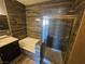 Elegant bathroom featuring a separate tub and glass-enclosed shower with dark wood-style wall tiles at 8309 Cherry Glaze Ave # 201, Las Vegas, NV 89145