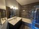 Elegant bathroom featuring a separate tub and glass-enclosed shower with dark wood-style wall tiles at 8309 Cherry Glaze Ave # 201, Las Vegas, NV 89145