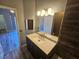 Stylish bathroom featuring a modern vanity, sleek lighting, a large mirror, and wood-look flooring at 8309 Cherry Glaze Ave # 201, Las Vegas, NV 89145