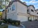 Ironwood Condominiums building with attached garages, landscaping, and brick driveway at 8309 Cherry Glaze Ave # 201, Las Vegas, NV 89145