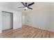 This bedroom offers wood floors, a ceiling fan, white walls, and a closet with sliding doors for ample storage at 9621 Blue Bell Dr, Las Vegas, NV 89134