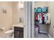 A well-organized open closet adjacent to a bathroom, featuring ample storage solutions at 1189 Hillside Peak St, Henderson, NV 89002