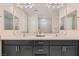 Bathroom with a double sink vanity with dark cabinets, large mirrors, and modern lighting at 1189 Hillside Peak St, Henderson, NV 89002