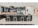 View of kitchen island with pendant lights, bar seating, dark cabinetry, and stainless steel appliances at 1189 Hillside Peak St, Henderson, NV 89002