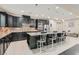 This open kitchen features a large island with seating, dark cabinetry, granite countertops, and modern lighting fixtures at 1189 Hillside Peak St, Henderson, NV 89002