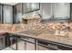A close-up view shows the beautiful countertops and backsplash in this modern kitchen with stainless steel hood at 1189 Hillside Peak St, Henderson, NV 89002