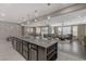 Bright kitchen shows island with seating, stainless appliances, dark cabinets, and open view to living spaces at 1189 Hillside Peak St, Henderson, NV 89002