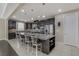 Bright kitchen shows island with seating, stainless appliances, dark cabinets, and open view to living spaces at 1189 Hillside Peak St, Henderson, NV 89002