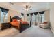 Spacious primary bedroom with a ceiling fan and large windows dressed with dark curtains at 1189 Hillside Peak St, Henderson, NV 89002