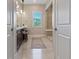 Hallway view of neutral bathroom showcasing a vanity with a chair and a glass-enclosed shower at 120 Los Cabos Dr # 301, Las Vegas, NV 89144