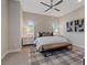Bright bedroom has a large, upholstered bed with a ceiling fan, and stylish window treatments at 120 Los Cabos Dr # 301, Las Vegas, NV 89144