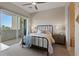 Bright bedroom featuring a modern ceiling fan, a comfortable bed and a sliding glass door to a private balcony at 120 Los Cabos Dr # 301, Las Vegas, NV 89144