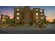 A beautifully landscaped building exterior at dusk features ample parking and well-lit grounds at 120 Los Cabos Dr # 301, Las Vegas, NV 89144