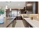 Modern kitchen with a large island featuring a sink, quartz countertops, stylish backsplash, and stainless steel appliances at 120 Los Cabos Dr # 301, Las Vegas, NV 89144
