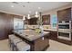 Modern kitchen with dark wood cabinets, stainless steel appliances, and an oversized island with seating at 120 Los Cabos Dr # 301, Las Vegas, NV 89144
