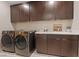 Well-equipped laundry room with dark cabinets, modern appliances, ample counter space, and a utility sink at 120 Los Cabos Dr # 301, Las Vegas, NV 89144