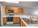 Galley kitchen with wood cabinets and stainless steel sink at 1800 Edmond St # 124, Las Vegas, NV 89146