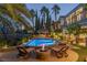 Expansive backyard with a luxurious pool, fire pit, and ample seating at 1975 Alcova Ridge Dr, Las Vegas, NV 89135
