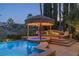 Lush landscaping surrounds this inviting spa and pool with a thatched roof cabana at 1975 Alcova Ridge Dr, Las Vegas, NV 89135