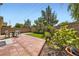 Brick paved backyard with a small patch of artificial turf and lush greenery at 2905 Vigilante Ct, North Las Vegas, NV 89081