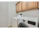 Laundry room with washer and dryer, as well as upper cabinets for storage at 2905 Vigilante Ct, North Las Vegas, NV 89081