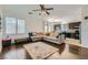 Inviting living room with a large sectional sofa, ceiling fan, and a view into the kitchen at 2905 Vigilante Ct, North Las Vegas, NV 89081