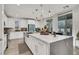 Bright kitchen featuring white cabinets, stone countertops, a kitchen island with seating, and modern light fixtures at 3197 Vittoria Ave, Henderson, NV 89044