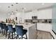 Bright kitchen boasts white cabinetry, stainless steel appliances, and an island with stylish seating at 3197 Vittoria Ave, Henderson, NV 89044
